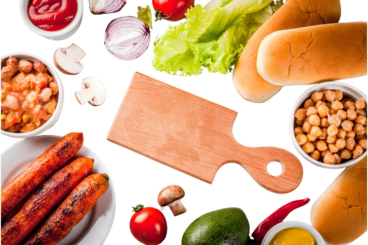 Assortment of fresh ingredients including buns, sausages, tomatoes, onions, and condiments for making delicious hot dogs