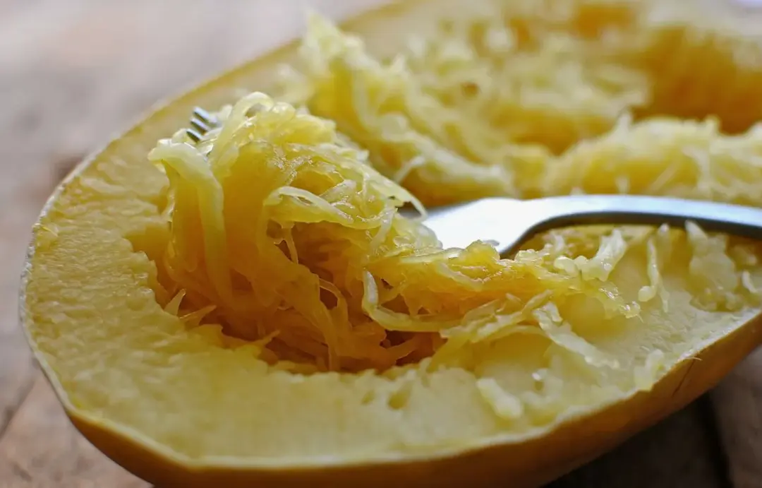 Whole spaghetti squash cooking in a slow cooker, steam visible