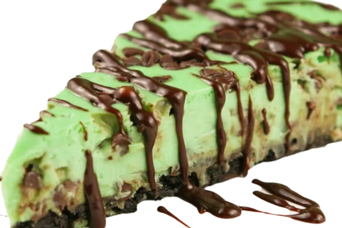 Slice of Classic 1960s Mint Chocolate Pie with mint leaf and chocolate curls, showcasing no-bake dessert finesse.