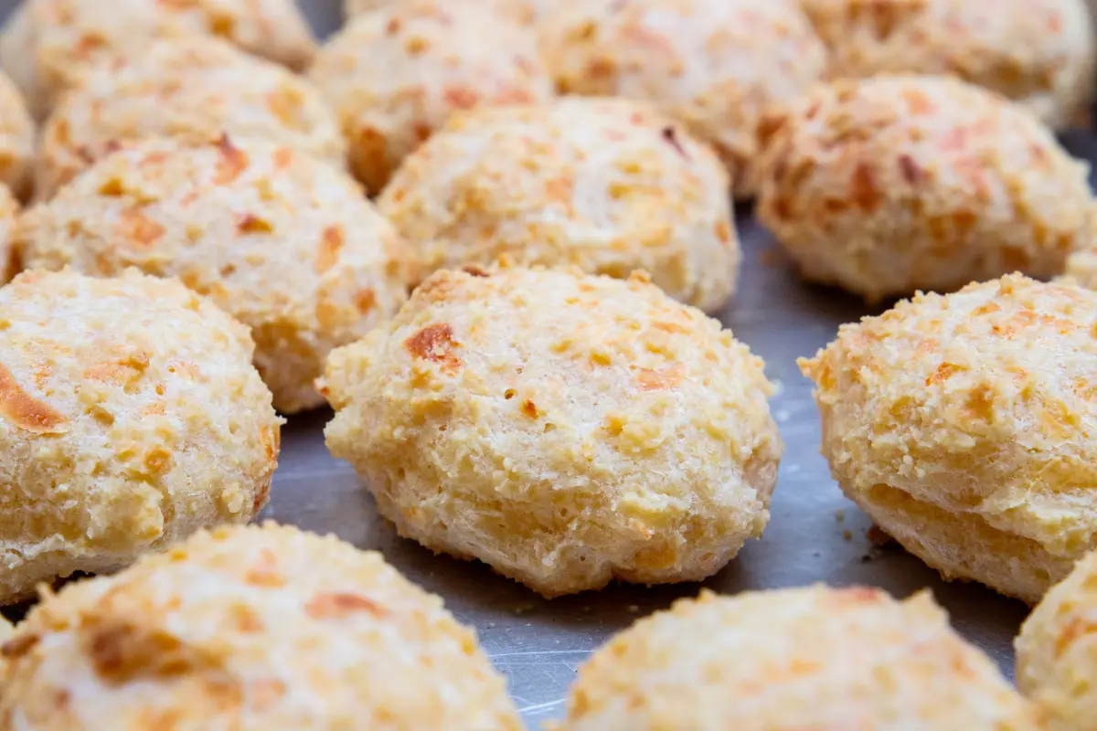 GPT A tray of freshly baked, golden-brown cheese biscuits.